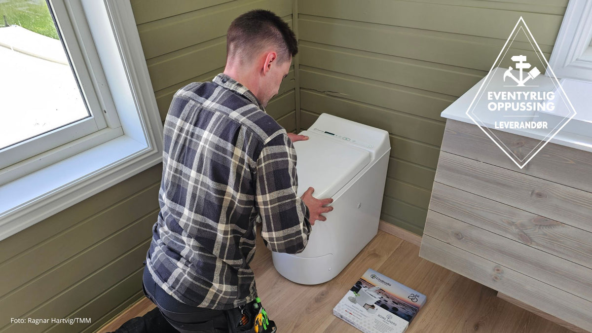 Man installing a Cinderella incineration toiolet i a cozy green bathroom.