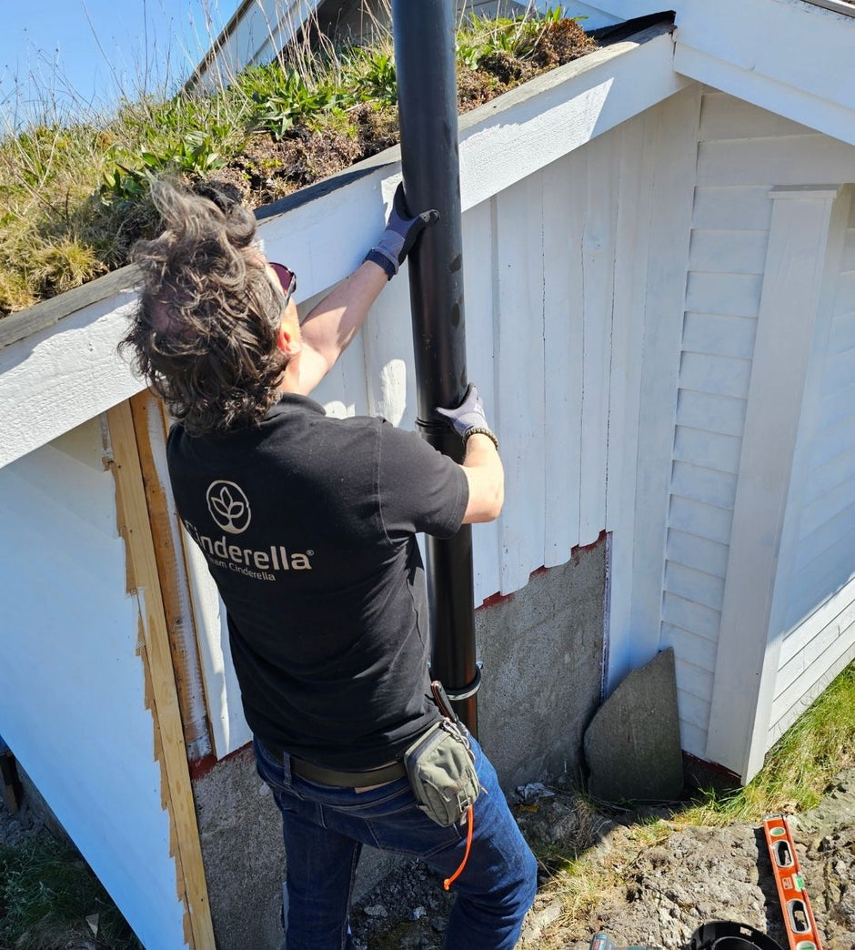 Person with Cinderella-branded shirt installing a Cinderella vent pipe on a guest house.