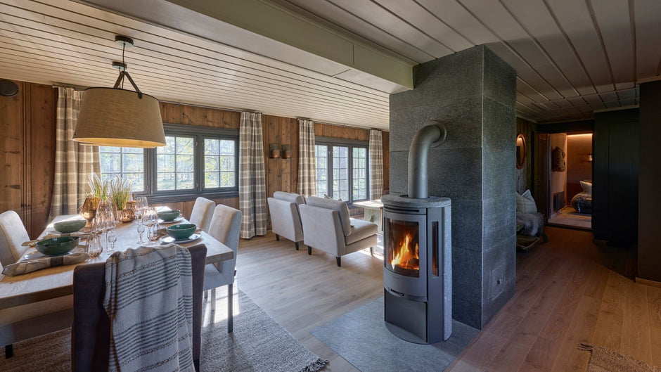 Viihtyisä olohuone, jossa on kivitakka ja puukalusteet.