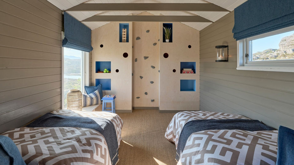 Lasten makuuhuone, jossa on kaksi sänkyä, kiipeilyseinä ja värikäs sisustus.